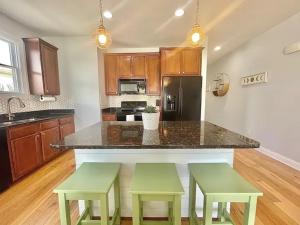 a kitchen with a island with two green stools at Chubby Seahorse 1 in Carolina Beach