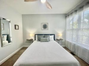 1 dormitorio con 1 cama blanca grande y ventilador de techo en Chubby Seahorse 1 en Carolina Beach