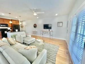 a living room with a white couch and a tv at Chubby Seahorse 1 in Carolina Beach