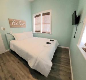 a white bed in a room with a window at Beachwood Bungalow B in Carolina Beach
