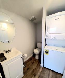 een badkamer met een wastafel, een toilet en een spiegel bij Beachwood Bungalow B in Carolina Beach