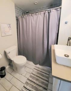 a bathroom with a toilet and a sink and a shower at Beachwood Bungalow B in Carolina Beach