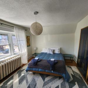 um quarto com uma cama e uma grande janela em The Pandora Century Home em Kitchener