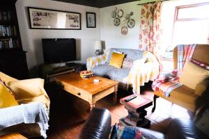 a living room with a couch and a table at Authentic Irish Cottage, Rural Ballymascanlon in Ballymascanlan