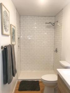 a white bathroom with a toilet and a shower at Island Time in Carolina Beach