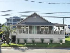 a white house with a large white porch at Island Time in Carolina Beach