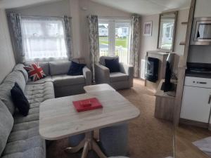 a living room with a couch and a table at 8 Berth 3 Bed PG213 on the Golden Palm in Chapel Saint Leonards