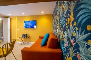 a living room with an orange couch and a colorful wall at La Casetta a Sorrento in Sorrento +9 photos