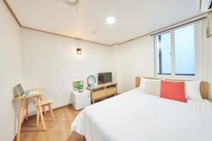 1 dormitorio con 1 cama, escritorio y TV en K'STAY Sinchon en Seúl