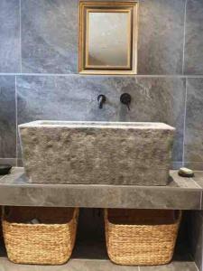 a stone sink in a bathroom with a mirror at LE REFUGE DE LUCE in Saint-Gervais-les-Bains