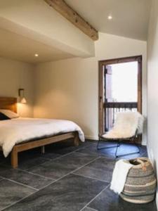 a bedroom with a bed and a mirror and a chair at LE REFUGE DE LUCE in Saint-Gervais-les-Bains