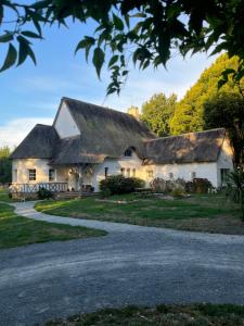 een huisje met een rieten dak en een oprit bij Gîte de charme avec jolie vue in Saint-Lyphard