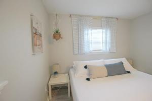 キュリビーチにあるSea-Estaの白いベッドルーム(ベッド1台、テーブル付)