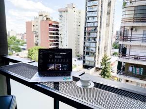 a laptop computer sitting on a table on a balcony at Santa Fe STAR -Cochera xa autos in San Miguel de Tucumán