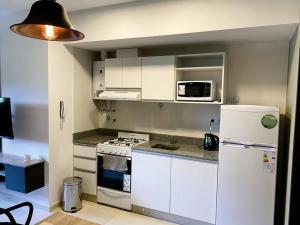 a kitchen with white cabinets and a white refrigerator at Santa Fe STAR -Cochera xa autos in San Miguel de Tucumán