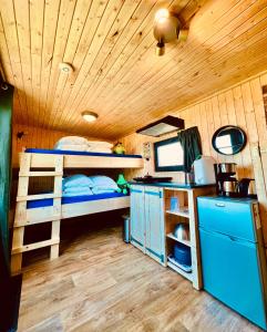 a room with two bunk beds and a desk at Tinyhouse Spiegelpeer in Ruinerwold