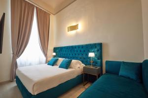 フィレンツェにあるResidenza Maglioni al Battisteroのベッドルーム(青いベッド1台、ソファ付)