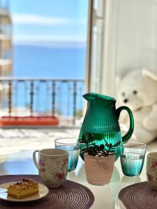 a green vase sitting on top of a table with cups at Luxury Tenao palace, Monaco border, sea view in Beausoleil