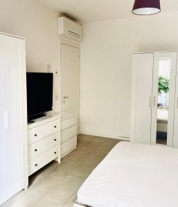 a bedroom with a bed and a flat screen tv at Lupicante 56 Cesenatico in Cesenatico