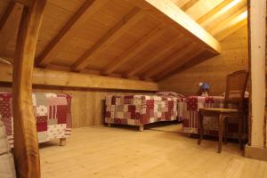 a attic room with two beds and a wooden ceiling at Ferme-Auberge du Rondeau in Lavans-Vuillafans