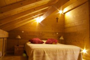 um quarto com uma cama num quarto de madeira em Ferme-Auberge du Rondeau em Lavans-Vuillafans