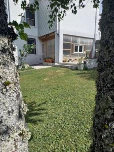 ein Haus mit einem Garten mit grünem Gras in der Unterkunft Gîte Lesmyosotis-messeix ***espace et calme 2/3p in Messeix