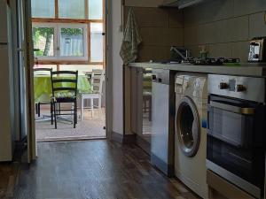 una cucina con lavatrice accanto a un tavolo di Gîte Lesmyosotis-messeix ***espace et calme 2/3p a Messeix