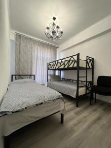 1 dormitorio con 2 literas y lámpara de araña en ЦО Париж сектор С18/5, en Chok-Tal
