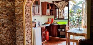a kitchen with a brick wall and a white refrigerator at Keelan ace villas in Kampala