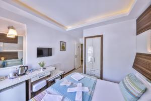 a small room with a bed and a sink at Hotel Sonne - Adults Only in Kaş