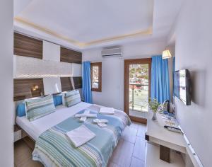a bedroom with a bed and a desk and a window at Hotel Sonne - Adults Only in Kaş