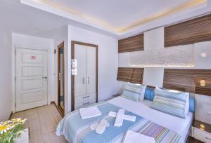 a bedroom with a large bed with towels on it at Hotel Sonne - Adults Only in Kaş