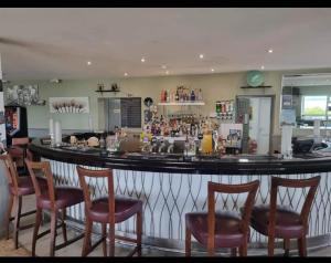 a bar in a restaurant with chairs around it at 3 bed caravan in Kirkcolm