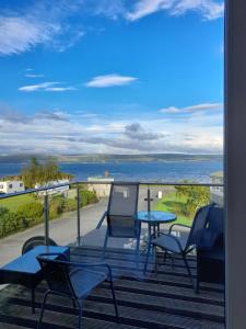 a balcony with chairs and a table and a view of the ocean at 3 bed caravan in Kirkcolm