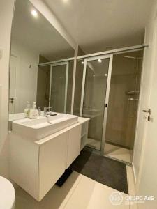 a bathroom with a white sink and a shower at XENON PRIME Urban Apartments in Maputo