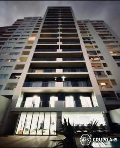 wysoki biały budynek z wieloma oknami w obiekcie XENON PRIME Urban Apartments w mieście Maputo