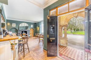 uma cozinha em plano aberto e sala de jantar com uma porta que leva a uma área de refeições em The Whichcote Arms 