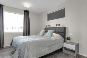 a white bedroom with a bed and a window at Bella Apartments & Rooms in Selfoss