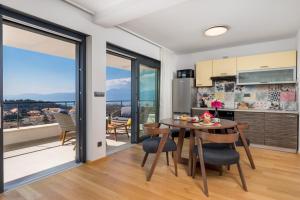 a kitchen and dining room with a table and chairs at Tersatto in Rijeka