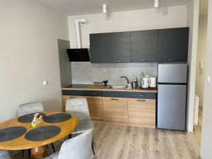 a kitchen with a wooden table and a refrigerator at Apartament Letnia 28 in Kłodzko