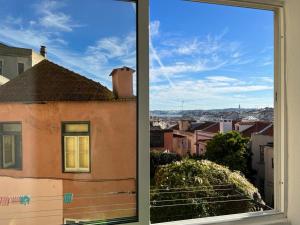 ein offenes Fenster mit Stadtblick in der Unterkunft Graça River View in Lissabon