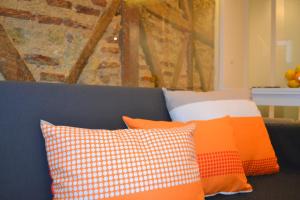 ein Sofa mit orangefarbenen und weißen Kissen darauf in der Unterkunft TP BICA 20, Lisbon Apartment in Lissabon