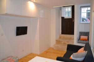 ein Wohnzimmer mit einem Sofa und einem TV in der Unterkunft TP BICA 20, Lisbon Apartment in Lissabon