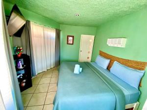 a bedroom with a blue bed in a green room at Casa Rofo in Guanajuato