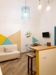 Zimmer mit Sofa, Tisch und Schreibtisch in der Unterkunft La Casetta di Zoe Apartment in Molfetta