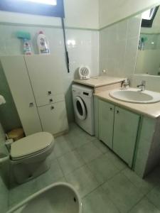 een badkamer met een wastafel en een wasmachine bij My Nest in Arzachena