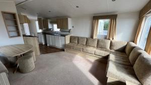 a living room with a couch and a table at 8 berth caravan PG214 Golden Palm Chapel st Leonards in Chapel Saint Leonards