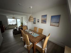 a living room with a dining room table and chairs at Wohnungen mit direktem Meerblick in Laboe