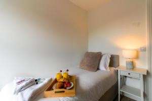 a bedroom with a bed with a tray of fruit on it at Walton by Pay As U Stay in Milton Keynes