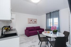 kuchnia i salon z fioletową kanapą w obiekcie Apartments Marina w Bibinje